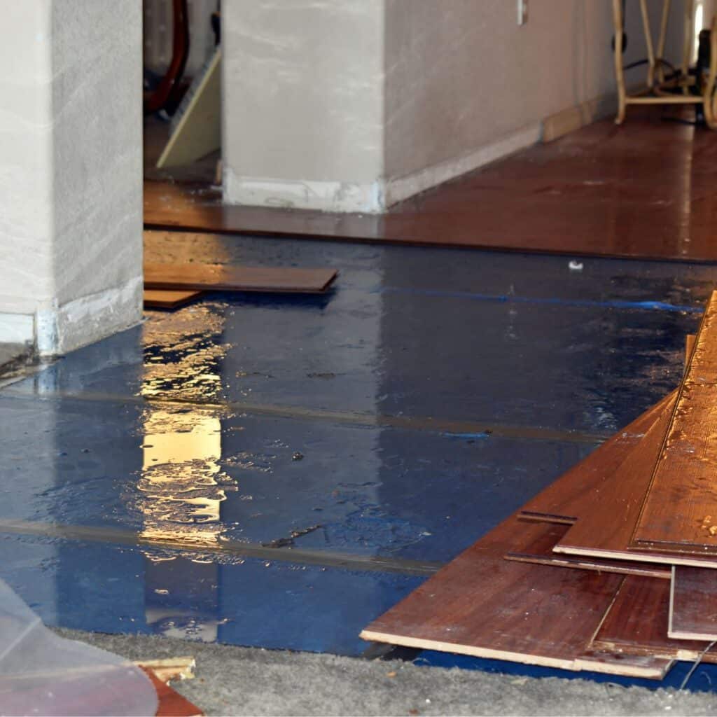 Water damage in a San Diego home with standing water under hardwood flooring during restoration by Mighty Dry Fire and Flood.